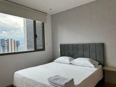 a bedroom with a large bed with a window at Amazing 3 bedroom near Provenza- El Poblado 701 in Medellín