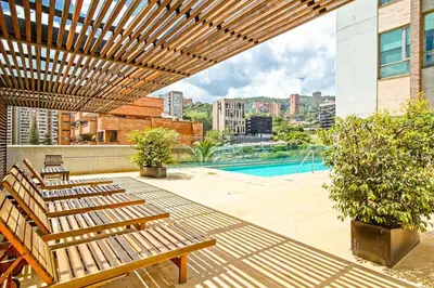 a patio with wooden benches and a pool at Amazing 3 bedroom near Provenza- El Poblado 701 in Medellín