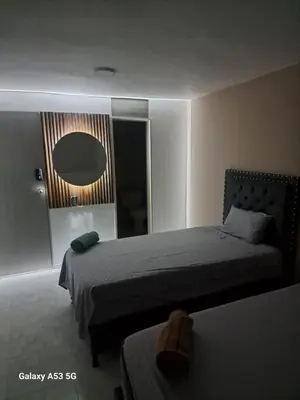 a hotel room with two beds and a mirror at Hotel Boutique Casa Teresita in Medellín