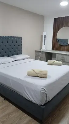 a bedroom with a large bed with two towels on it at Hotel Boutique Casa Teresita in Medellín