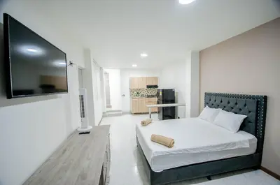 a bedroom with a bed and a flat screen tv at Hotel Boutique Casa Teresita in Medellín
