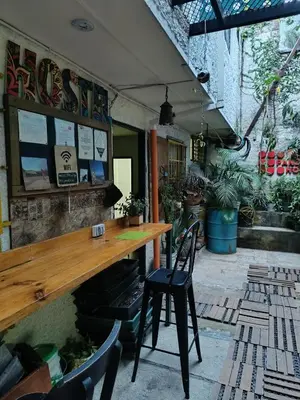 a bar in a restaurant with two chairs and a table at Panela Hostel Poblado in Medellín