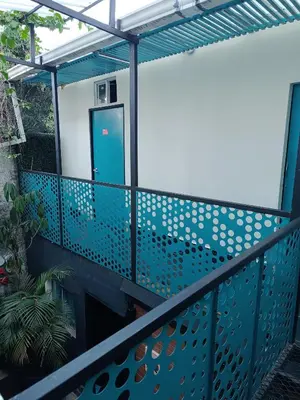 a balcony with a blue metal railing with a door at Panela Hostel Poblado in Medellín