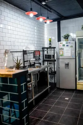a kitchen with a refrigerator and a sink and a counter at Panela Hostel Poblado in Medellín