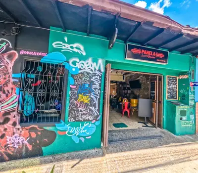 a green building with graffiti on the side of it at Panela Hostel Poblado in Medellín