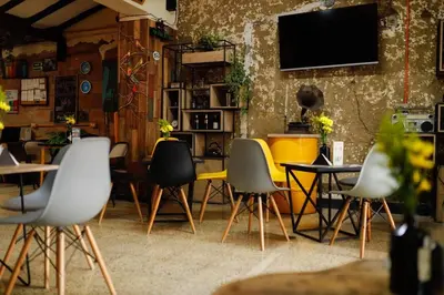 a room with chairs and a table and a tv at Panela Hostel Poblado in Medellín