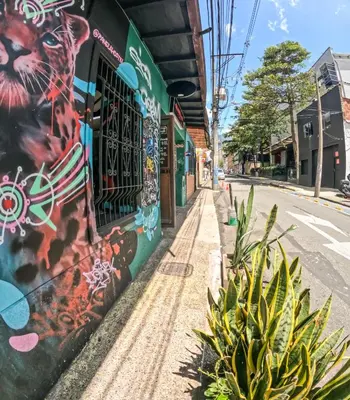 a street with graffiti on the side of a building at Panela Hostel Poblado in Medellín