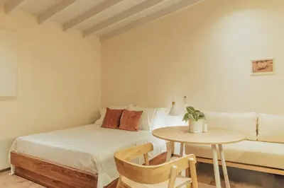 a bedroom with a bed and a table and a couch at New designed Loft in Laureles with AC and WiFi in Medellín