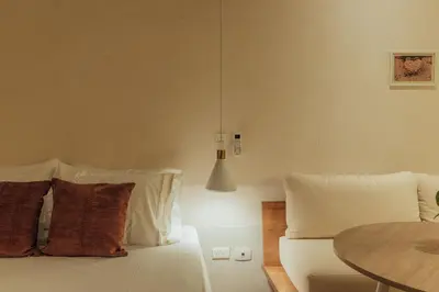 a bedroom with a bed with pillows and a table at New designed Loft in Laureles with AC and WiFi in Medellín