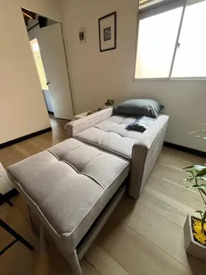 two beds in a living room with a window at Lucia Metro House in Medellín