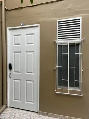 a white door and a window on the side of a house at Lucia Metro House in Medellín