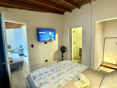 a bedroom with a bed and a tv on the wall at Lucia Metro House in Medellín
