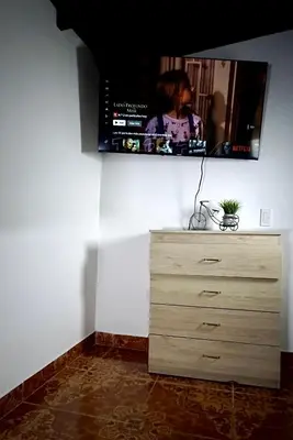 a tv on a wall with a wooden dresser at Inolvidable experiencia en Jericó, lugar tranquilo in Jericó
