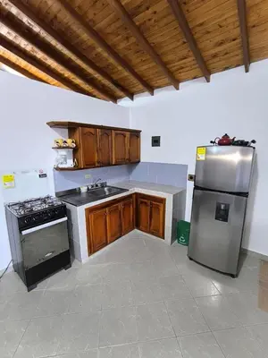 a kitchen with wooden cabinets and a stainless steel refrigerator at aparta hotel La Gruta Jericó, apartamento con balcón in Jericó