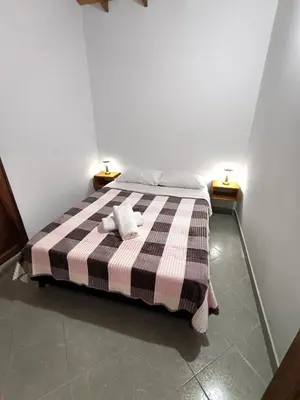 a bedroom with a bed with a checkered blanket at aparta hotel La Gruta Jericó, apartamento con balcón in Jericó