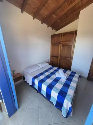 a bedroom with a blue and white checkered bed at aparta hotel La Gruta Jericó, apartamento con balcón in Jericó