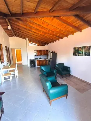 a living room with green furniture and a kitchen at aparta hotel La Gruta Jericó, apartamento con balcón in Jericó