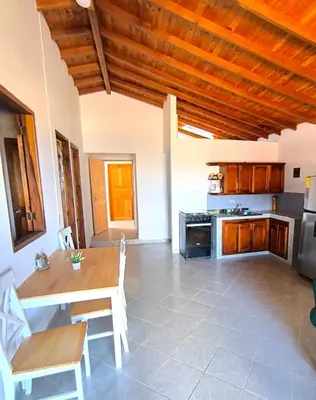 a kitchen with a wooden table and a wooden ceiling at aparta hotel La Gruta Jericó, apartamento con balcón in Jericó