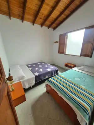 a bedroom with two beds and a window at aparta hotel La Gruta Jericó, apartamento con balcón in Jericó