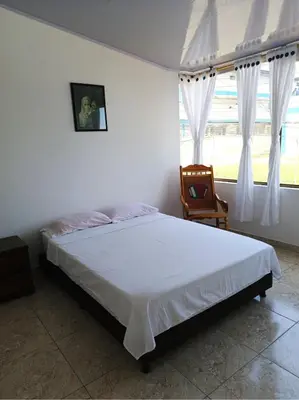 a bedroom with a bed and a chair and a window at Agradable y comodo apartamento en Manizales, barrio Chipre in Manizales