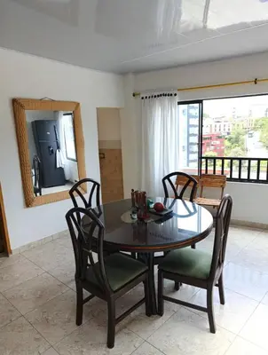 a dining room with a table and chairs and a mirror at Agradable y comodo apartamento en Manizales, barrio Chipre in Manizales