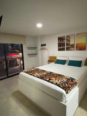 a bedroom with a bed with a leopard blanket on it at Hotel Olimpo La 47 in Rionegro