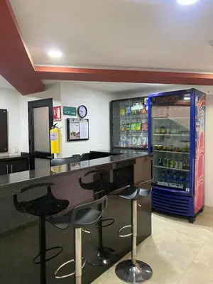 a drink bar with two stools and a soda machine at Hotel Olimpo La 47 in Rionegro