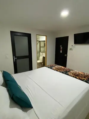 a bedroom with a large white bed in a room at Hotel Olimpo La 47 in Rionegro