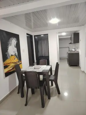 a dining room with a table and a painting of a horse at Aparta estudio amoblado en Chinchiná Caldas Eje Cafetero in Chinchiná