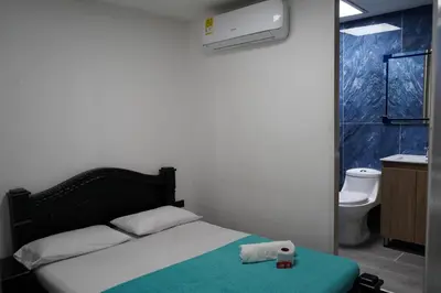 a bedroom with a bed and a bathroom with a toilet at Hotel Serymar la 70 in Medellín