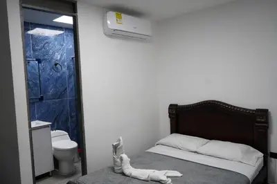 a small bedroom with a bed and a shower at Hotel Serymar la 70 in Medellín