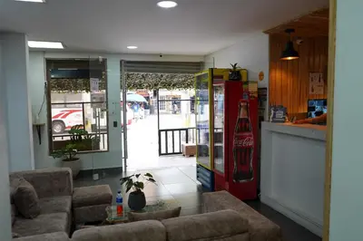 a living room with two couches and a coke machine at Hotel Serymar la 70 in Medellín