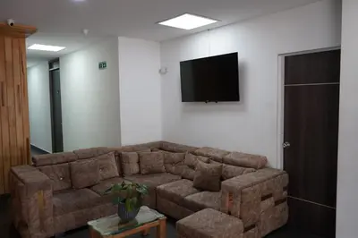 a living room with a couch and a flat screen tv at Hotel Serymar la 70 in Medellín