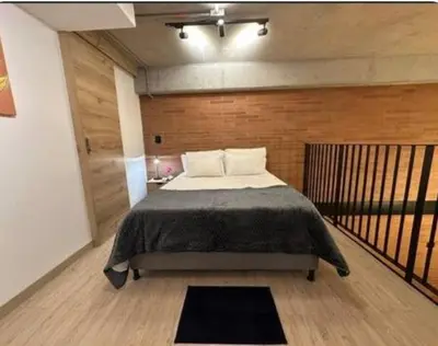 a bedroom with a bed and a wooden wall at Loft hermoso y céntrico 1109 in Medellín