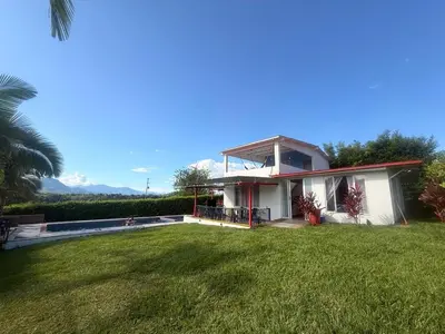 a house with a green lawn in front of it at Casa Campestre La Mesita in Palestina