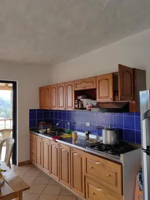 a kitchen with wooden cabinets and a stove top oven at Finca de Rubén in Olaya