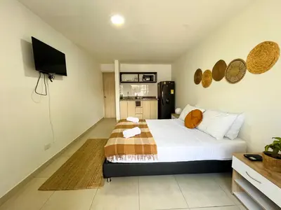a bedroom with a large bed and a kitchen at loft dreams 7006 in Medellín