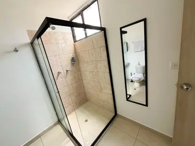 a glass shower in a bathroom with a mirror at loft dreams 7006 in Medellín