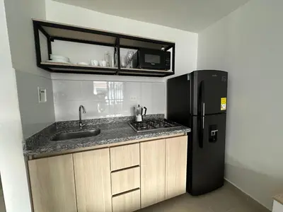 a kitchen with a sink and a black refrigerator at loft dreams 7006 in Medellín
