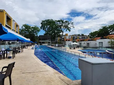 a large swimming pool with tables and umbrellas and buildings at Family Resort Santa Fe De Antioquia - Santa Fe de Antioquia in Santa Fe de Antioquia