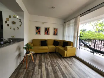 a living room with a yellow couch and a balcony at Family Resort Santa Fe De Antioquia - Santa Fe de Antioquia in Santa Fe de Antioquia
