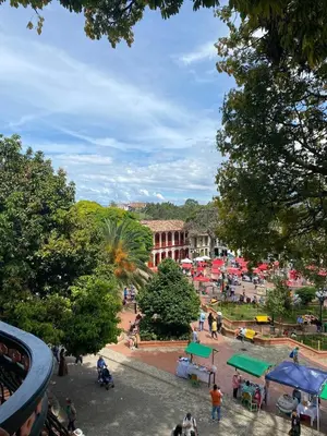 a group of people walking around a park at La Casa del Colibrí in Jericó