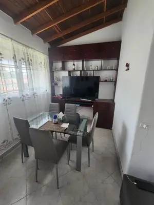 a dining room with a table and chairs and a television at comoda habitacion con baño compartido in Itagüí
