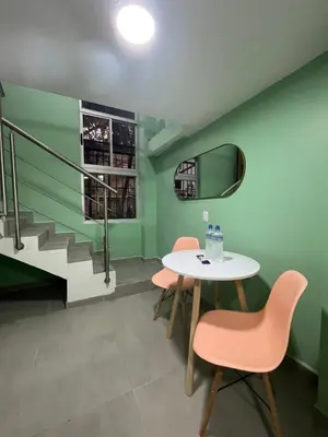 a table and chairs in a room with green walls at Amaranto Suites in Medellín