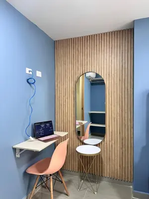 a room with a mirror and two chairs and a laptop at Amaranto Suites in Medellín