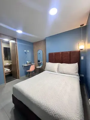 a bedroom with a large bed with a blue wall at Amaranto Suites in Medellín