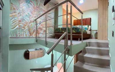 a staircase in a house with a mural on the wall at Amaranto Suites in Medellín