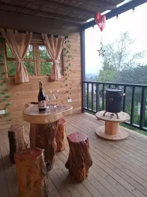 a wooden deck with a table with a bottle of wine at Alma Cabañas y Spa in Guarne