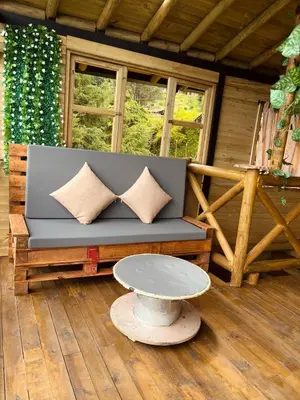 a couch on a porch with a table at Alma Cabañas y Spa in Guarne