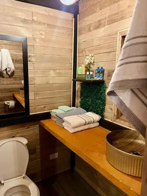 a bathroom with a toilet and a counter with towels at Alma Cabañas y Spa in Guarne